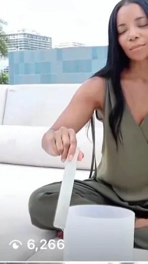 AUTHOR playing a crystal singing bowl in olive linen