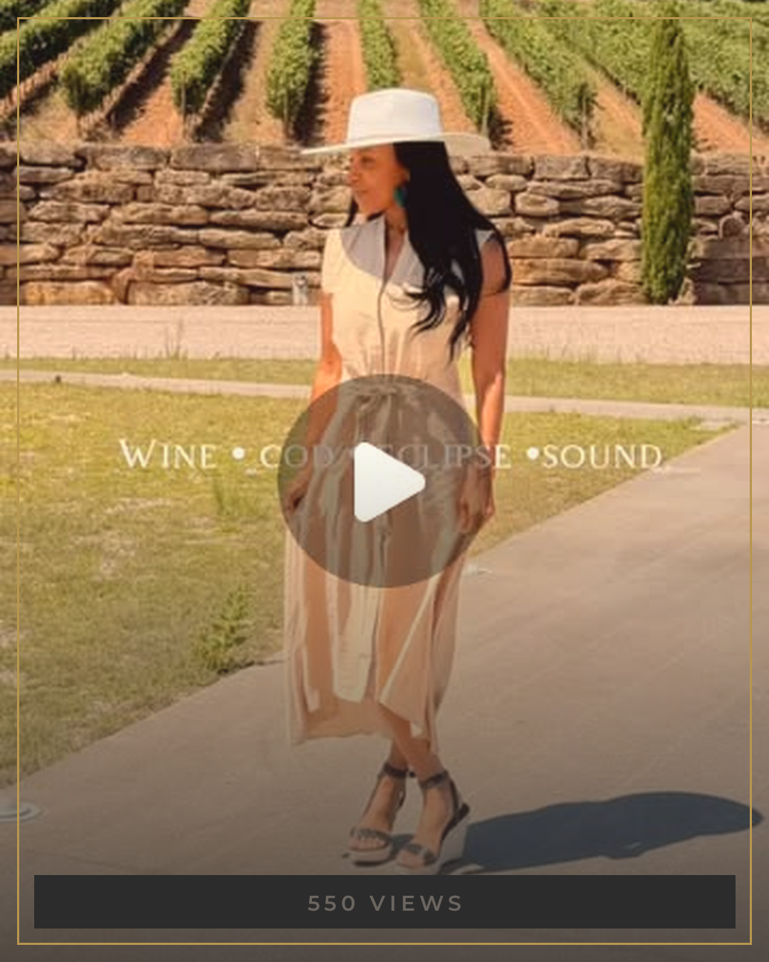 AUTHOR in a champagne dress and white wide brim hat at a vineyard