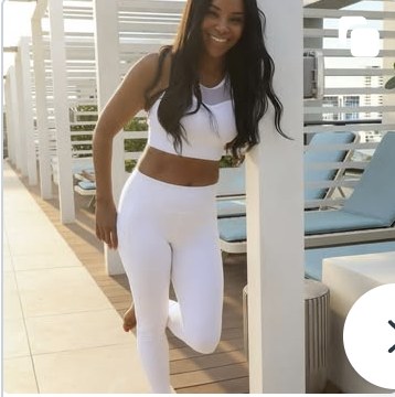 AUTHOR in a white activewear set on a sunlit terrace