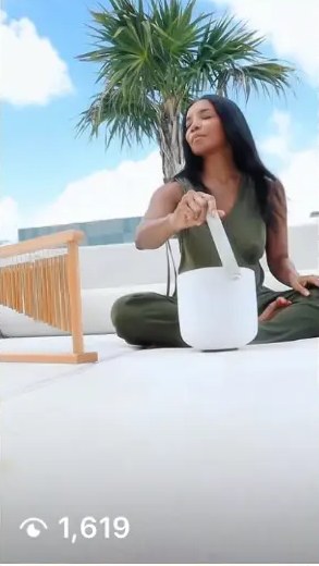 AUTHOR playing a singing bowl on a rooftop under palms